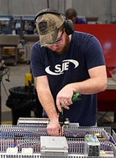sje employee working on a panel